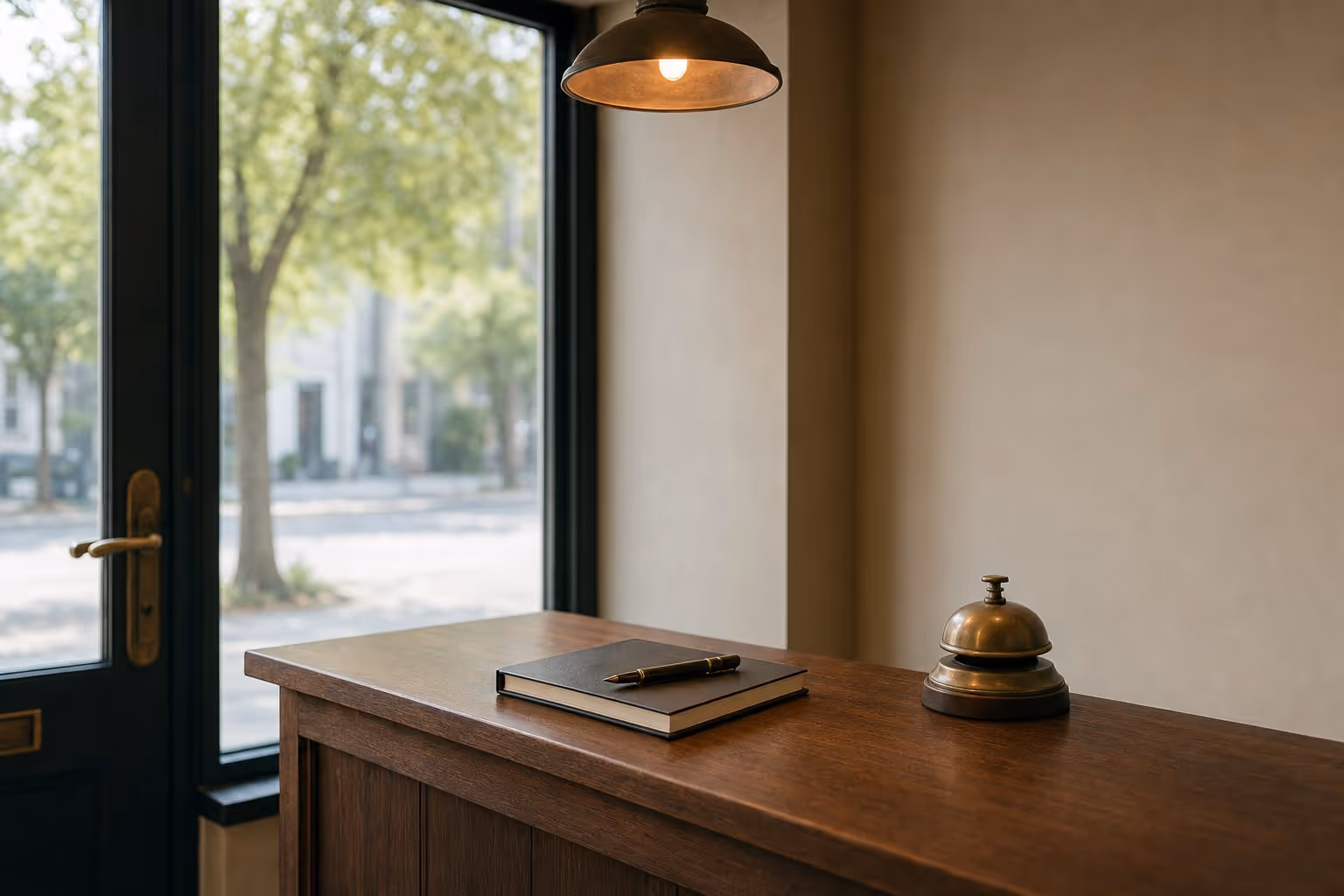 A quiet counter corner near the shop door, with a notebook, pen and service bell